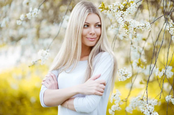 Ung kvinna på blossom bakgrund — Stockfoto