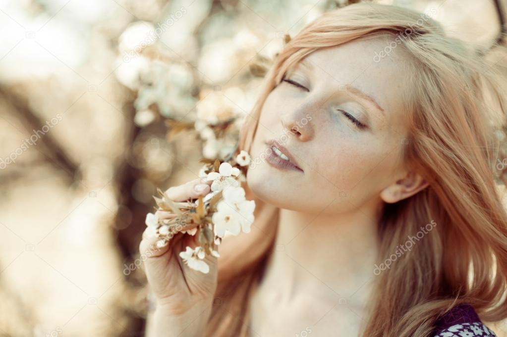 Picture of beautiful woman inhales the smell of spring