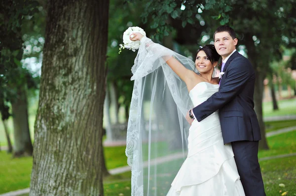 Young happy bride and groom enjoying freedom in a park — Stock Photo, Image