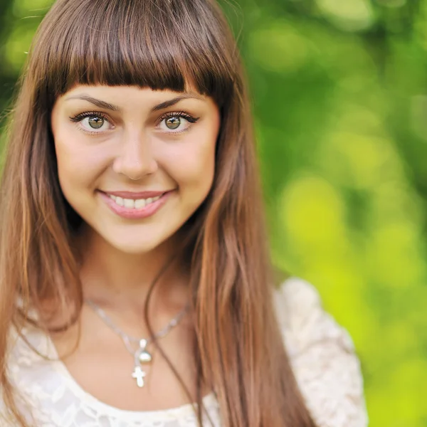 Mooi meisje gezicht op groene achtergrond close-up — Stockfoto