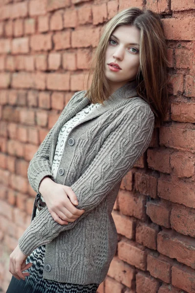 Krásná mladá dívka stojící proti zdi — Stock fotografie