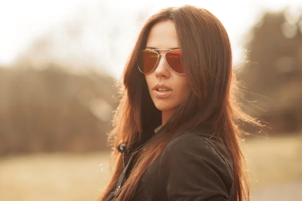 Outdoor fashion portrait of young brunette woman in sunglasses — Stock Photo, Image