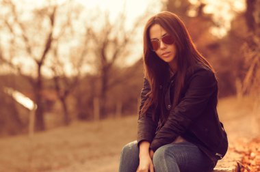 gün batımında güzel kadın modeli. güneş gözlüğü takıyor. Açık po