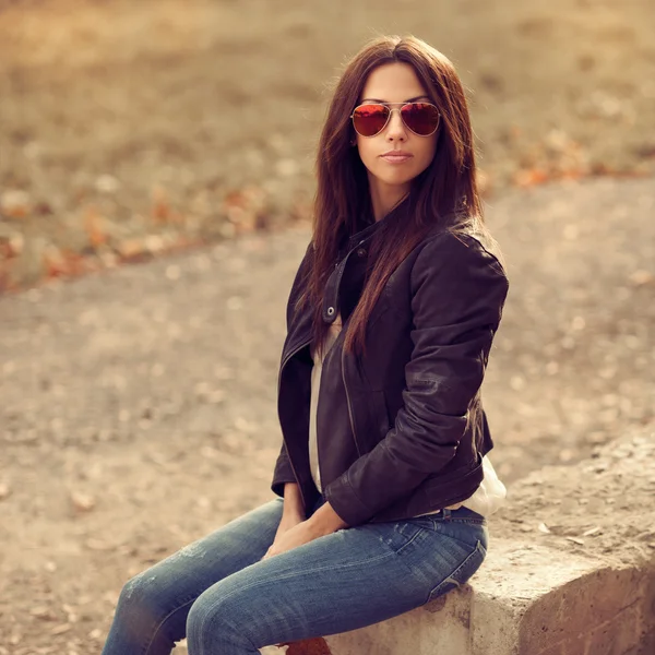 Jonge stijlvolle brunette vrouw poseren buiten — Stockfoto