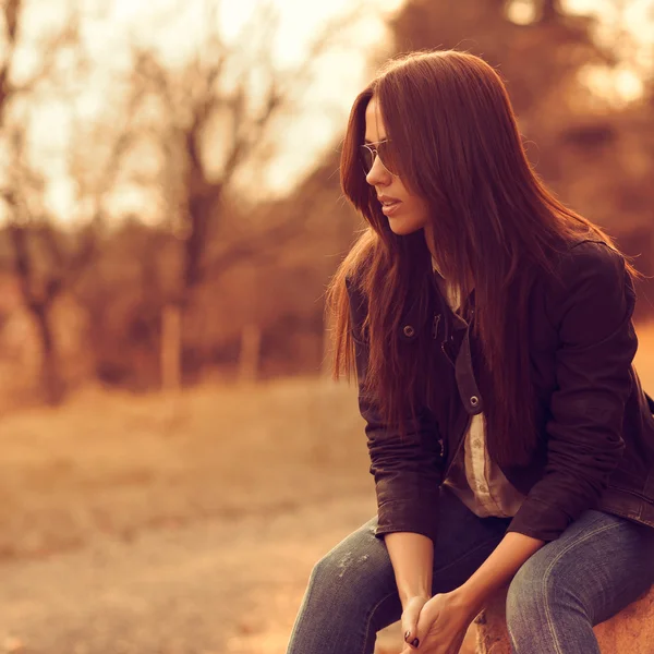 Beautiful female model at sunset. Wearing sunglasses. Outdoor po — Stock Photo, Image