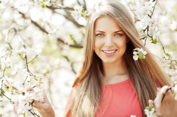 Mooi lente meisje in bloeiende boom — Stockfoto