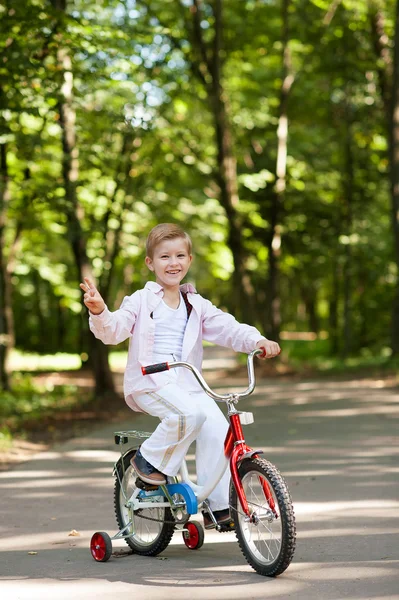 Menino de bicicleta em um parque — Fotografia de Stock