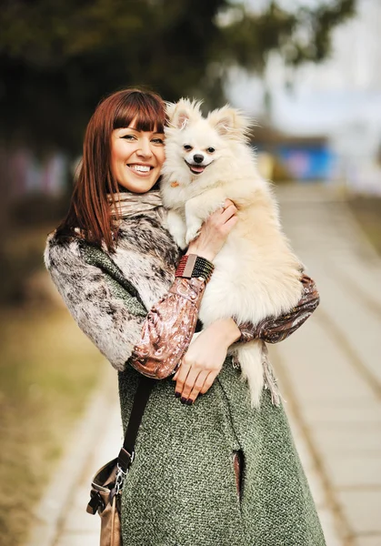 Jovem mulher feliz segurar em mãos pequeno cão ou cachorro - ao ar livre por — Fotografia de Stock