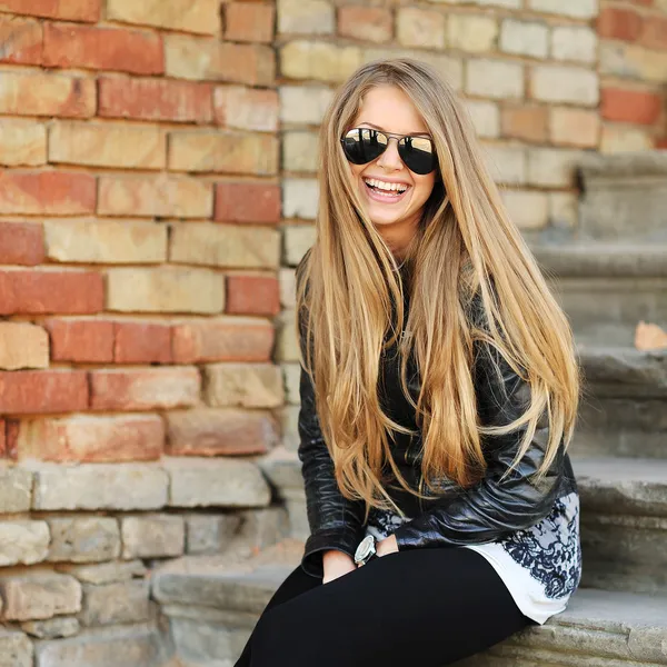Hermosa joven rubia mujer de pelo sentado en las escaleras y sonriendo w —  Fotos de Stock