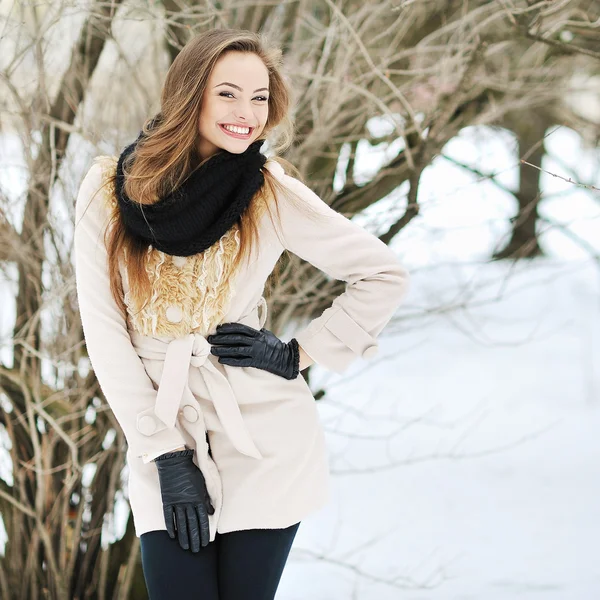 Menina bonita posando ao ar livre e sorrindo em um inverno perto — Fotografia de Stock