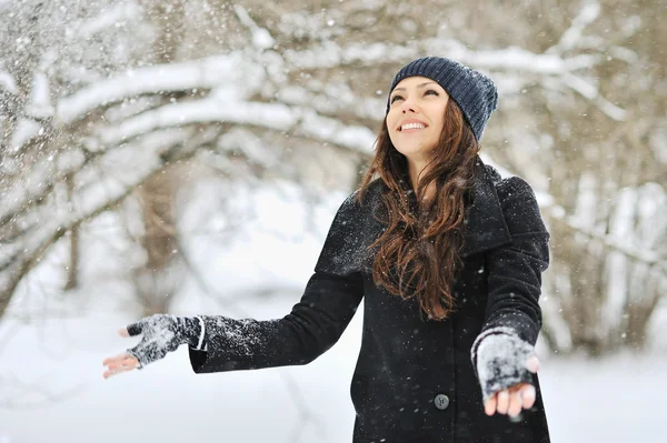 Beautiful woman playing with snow in park — Stock Photo, Image