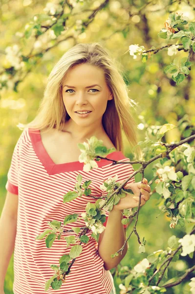 Jovem mulher no parque de verão perto de uma árvore florescente — Fotografia de Stock