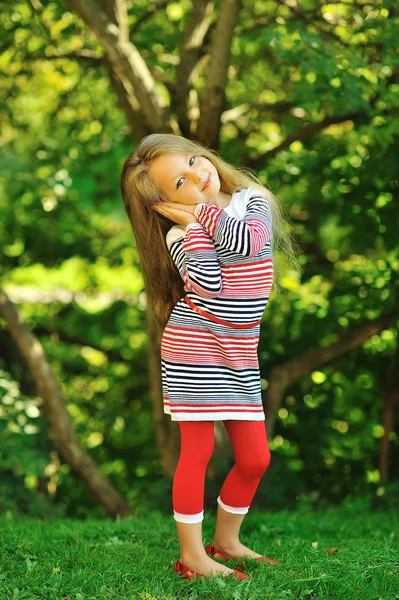 Ładny mały dziewczyna pozuje w zielone lato park - portret — Zdjęcie stockowe