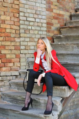 Kırmızı elbise açık havada poz içinde bir modeldir