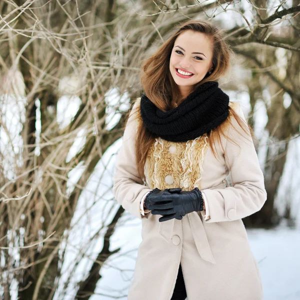 Случайный портрет красивой счастливой улыбающейся девушки в зимнем парке — стоковое фото