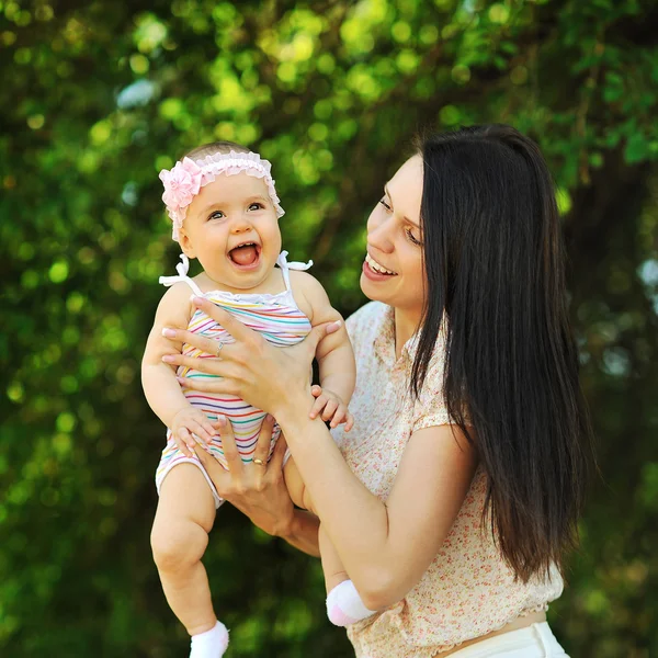 Mãe sorridente e bebê em um parque — Fotografia de Stock