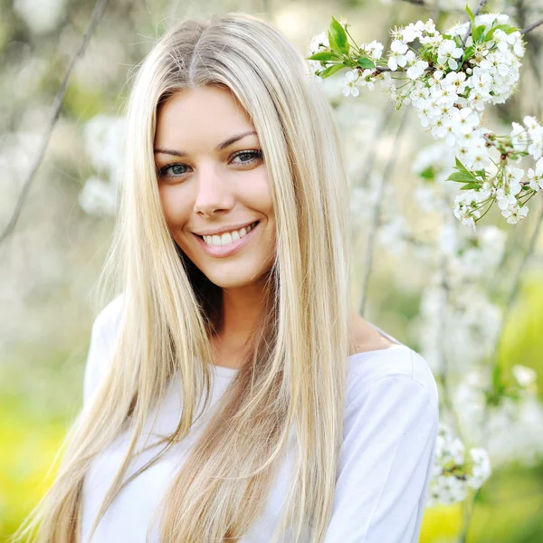 Skönhet våren flicka stående över blommande träd med blommor — Stockfoto