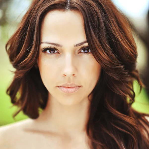 Ansikte av vacker ung kvinna med brunt lockigt hår och perfekt — Stockfoto
