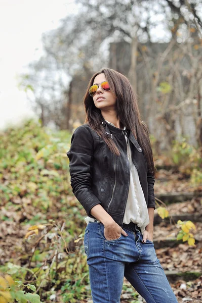 Belle jeune femme en lunettes de soleil posant sur la nature backgroun — Photo