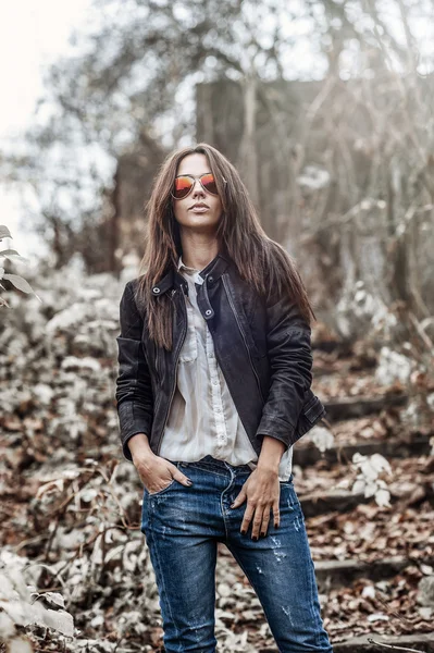 Hermosa mujer joven en gafas de sol posando sobre la naturaleza backgroun —  Fotos de Stock