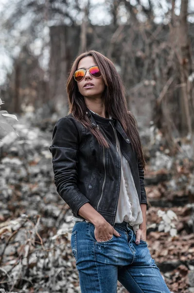 Hermosa mujer joven en gafas de sol posando sobre la naturaleza backgroun —  Fotos de Stock