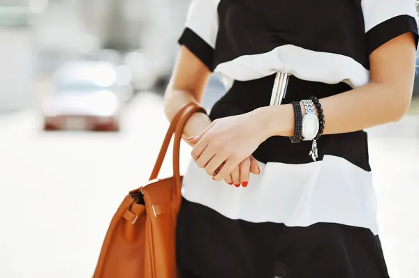 Fashionabla kvinna med handväska i händerna - närbild — Stockfoto