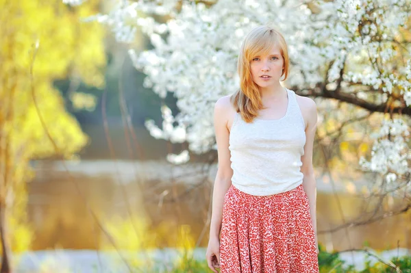 Portrait of beautiful woman in blooming tree in spring — Stock Photo, Image