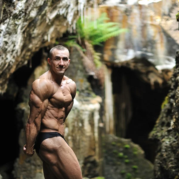 Portrait of a handsome muscular bodybuilder posing near a copysp — Stock Photo, Image