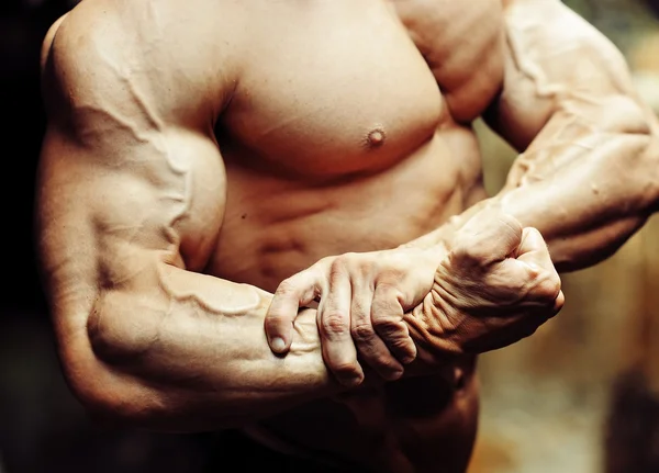 Close-up op een bodybuilder biceps. sterke arm- en borstspieren — Stockfoto