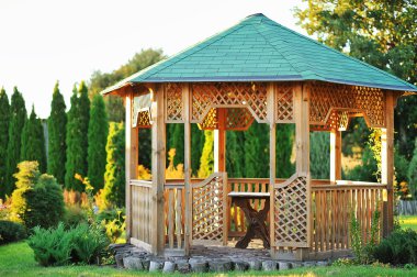 Outdoor wooden gazebo over summer landscape background clipart