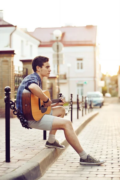Pohledný mladý muž s kytarou — Stock fotografie