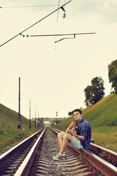 Schöner Mann mit Gitarre auf Eisenbahnstraße — Stockfoto