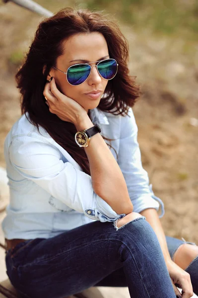 Jeune femme brune sexy en lunettes de soleil — Photo