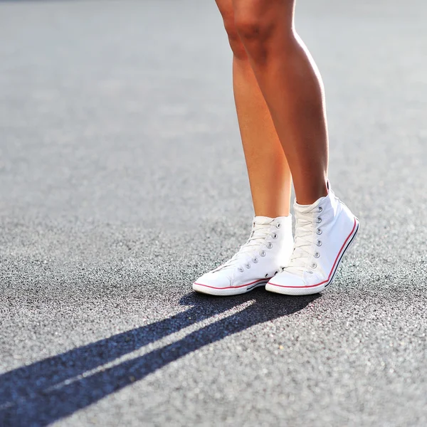 Gambe femminili in scarpe da ginnastica - primo piano — Foto Stock