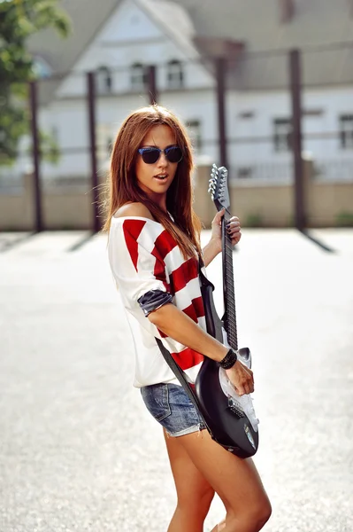 Hermosa y joven mujer de moda posando con guitarra eléctrica — Foto de Stock