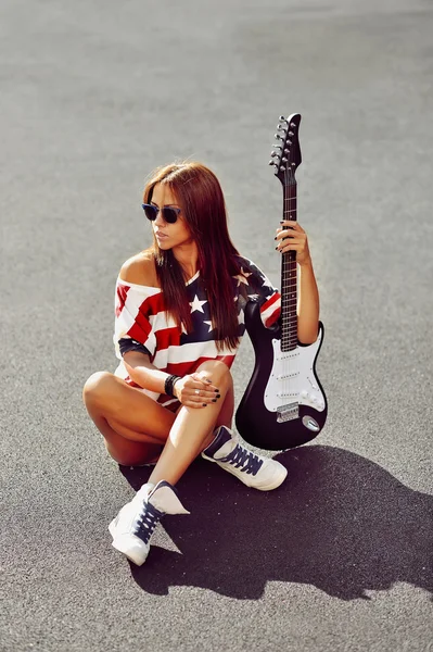 Ελκυστική νεαρή γυναίκα που ποζάρει με κιθάρα — Φωτογραφία Αρχείου