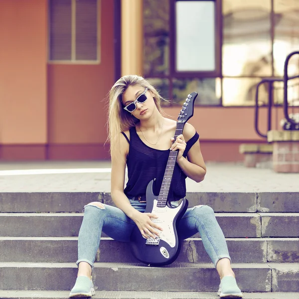 इलेक्ट्रिक गिटार के साथ युवा सुंदर महिला धूप का चश्मा पहनती है — स्टॉक फ़ोटो, इमेज