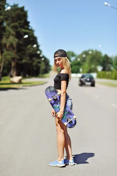 Piękna młoda kobieta trzyma na deskorolce — Zdjęcie stockowe