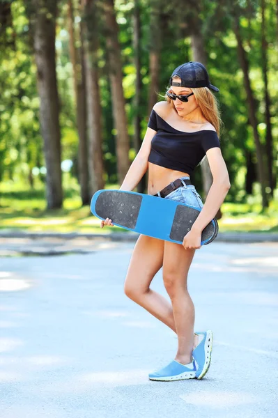 Όμορφη νέα γυναίκα που κρατά ένα skateboard — Φωτογραφία Αρχείου
