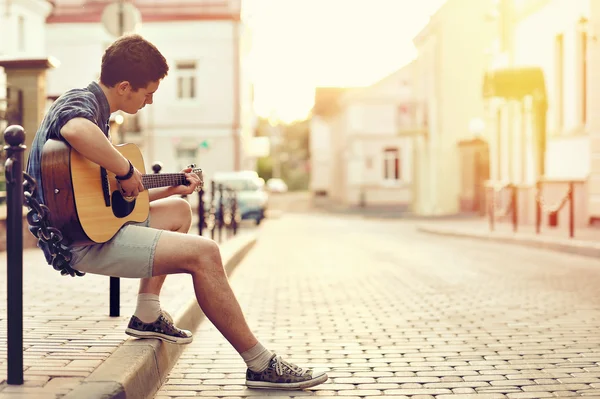 Jovem tocando guitarra acústica - ao ar livre — Fotografia de Stock