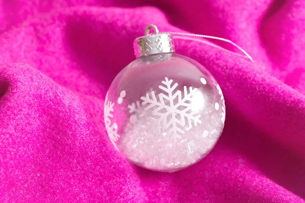 Creative Christmas background made with festive ball ornament and soft magenta knitting. Minimal composition. Cozy and warm New Years concept. — Stock Photo, Image