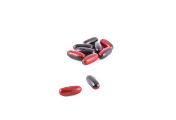 Red black capsules over white — Stock Photo, Image