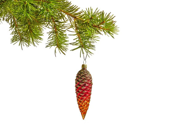 Brinquedo de cone vermelho de Natal e galho de árvore de pele em um fundo branco — Fotografia de Stock