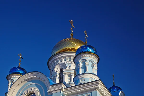 Iglesia ortodoxa blanco-azul con cúpulas azules y doradas contra th — Foto de Stock