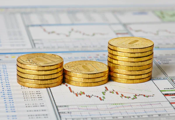 Financial settlement with the charts and golden coins. Selective — Stock Photo, Image