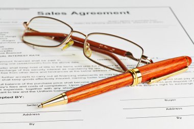 Contract with glasses and wooden pen ready to be signed clipart