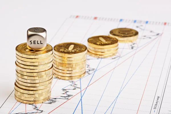 Coins stacks downtrend and the dices cube with the word SELL on — Stock Photo, Image