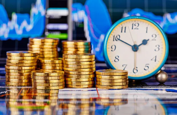 Stacks of golden coins, clock and the financial chart as backgro — Stock Photo, Image