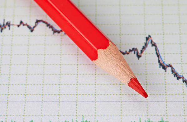 Gráfico de tendencia descendente financiera y lápiz rojo. Enfoque selectivo —  Fotos de Stock