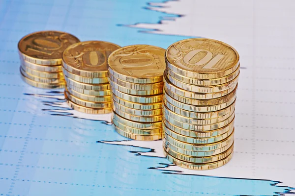 Opwaartse trend stapels munten, op de financiële voorraadgrafieken als achtergrond — Stockfoto